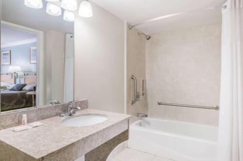 W łazience znajduje się umywalka, wanna i lustro. w obiekcie Super 8 by Wyndham Ft Walton Beach w mieście Fort Walton Beach