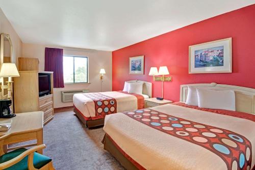 a hotel room with two beds and a television at Super 8 by Wyndham Albuquerque West/Coors Blvd in Albuquerque