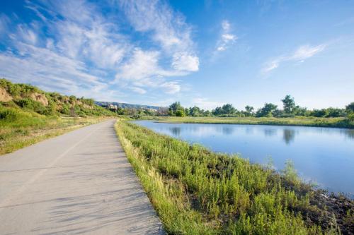 a path next to a river with a blue sky at Super 8 by Wyndham Casper West by the River in Casper
