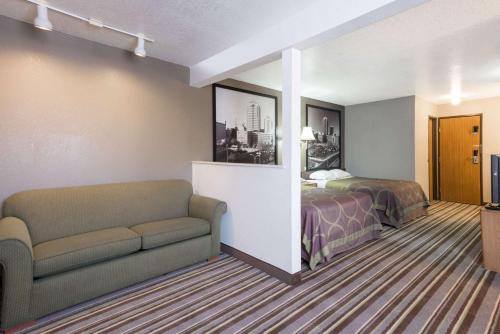 a hotel room with a bed and a couch at Super 8 by Wyndham Bernalillo in Bernalillo