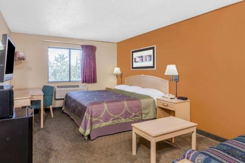 um quarto de hotel com uma cama e uma televisão em Super 8 by Wyndham Charlotte/Amusement Park Area em Charlotte