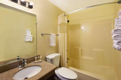 a bathroom with a toilet and a sink and a shower at Super 8 by Wyndham Alamogordo in Alamogordo