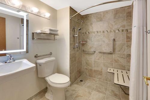 a bathroom with a shower and a toilet and a sink at Super 8 by Wyndham Cody in Cody