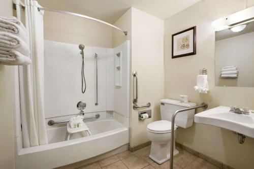 a bathroom with a tub and a toilet and a sink at Super 8 by Wyndham Bozeman in Bozeman
