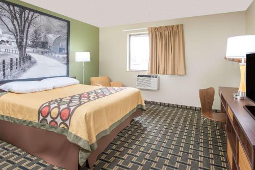 a small hotel room with a bed and a desk at Super 8 by Wyndham Youngstown/Austintown in Youngstown