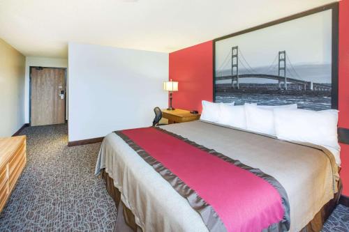 a hotel room with a large bed and a bridge at Super 8 by Wyndham West Branch in West Branch