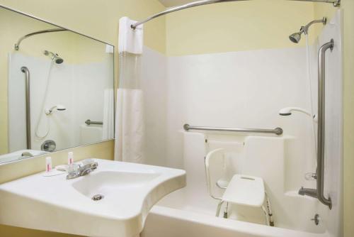 a white bathroom with a sink and a toilet at Super 8 by Wyndham Colby in Colby