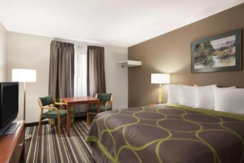 a hotel room with a bed and a desk at Super 8 by Wyndham Bozeman in Bozeman