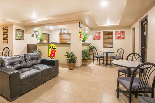 a living room with a couch and tables and chairs at Super 8 by Wyndham Colby in Colby