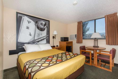 ein kleines Hotelzimmer mit einem Bett und einem Tisch in der Unterkunft Super 8 by Wyndham Casper West by the River in Casper
