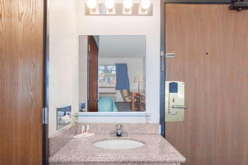 a bathroom with a sink and a mirror at Super 8 by Wyndham Selma/Fresno Area in Selma