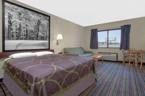 A bed or beds in a room at Super 8 by Wyndham Evansville East