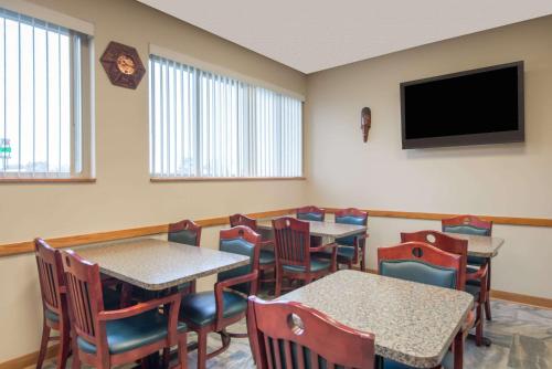 a dining room with tables and chairs and a flat screen tv at Super 8 by Wyndham Youngstown/Austintown in Youngstown