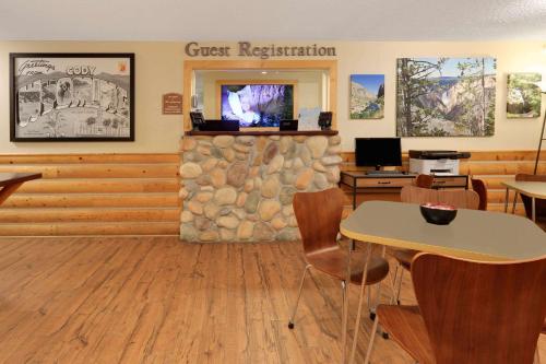 a restaurant with a stone wall and a table and chairs at Super 8 by Wyndham Cody in Cody