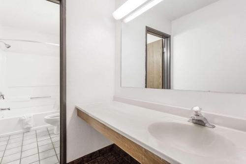 a white bathroom with a sink and a mirror at Super 8 by Wyndham Summersville in Summersville