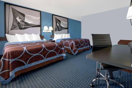 a hotel room with two beds and a desk at Super 8 by Wyndham Dumas TX in Dumas