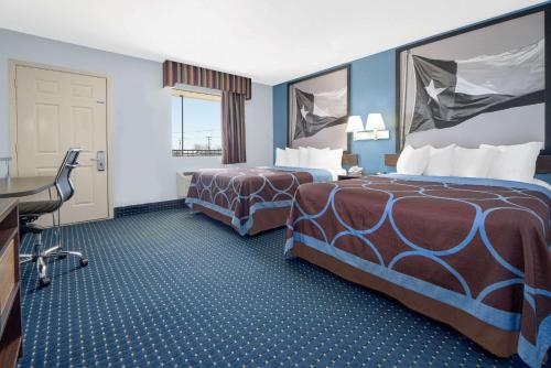 a hotel room with two beds and a desk at Super 8 by Wyndham Dumas TX in Dumas