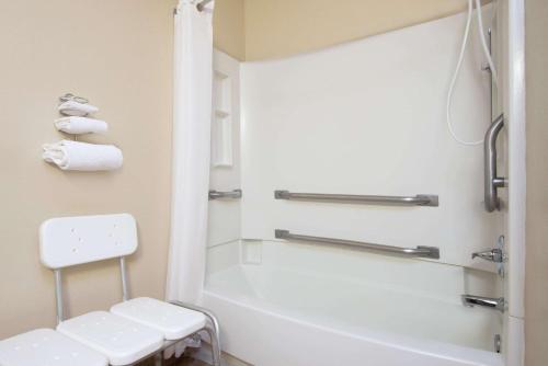 y baño con bañera blanca y aseo. en Super 8 by Wyndham Portales, en Portales