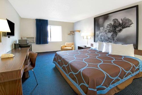 a hotel room with a large bed and a desk at Super 8 by Wyndham Las Cruces University Area in Las Cruces
