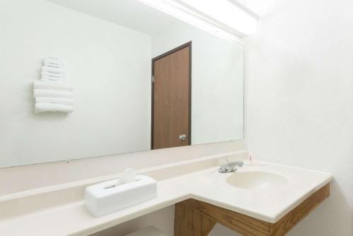 a white bathroom with a sink and a mirror at Super 8 by Wyndham Twinsburg/Cleveland Area in Twinsburg