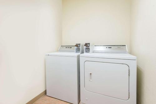 two white refrigerators sitting next to each other in a room at Super 8 by Wyndham Moriarty in Moriarty