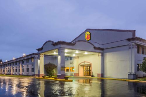 a building on a wet street in a parking lot at Super 8 by Wyndham Hartford in Hartford