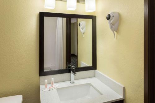 a bathroom with a sink with a mirror and a phone at Super 8 by Wyndham Marietta in Marietta