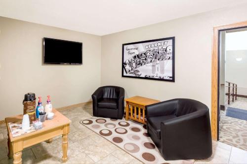 a living room with two chairs and a tv at Super 8 by Wyndham Kearney in Kearney