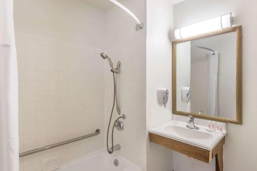 a bathroom with a shower and a sink and a mirror at Super 8 by Wyndham Hartford in Hartford