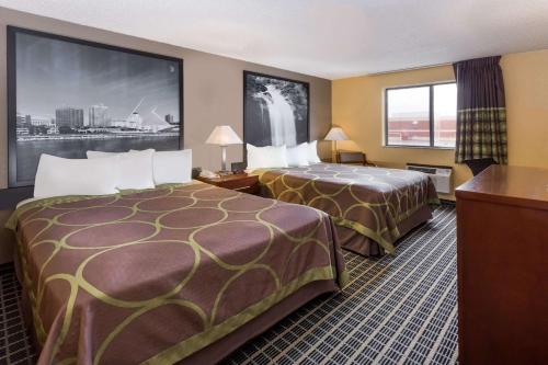 a hotel room with two beds and a large window at Super 8 by Wyndham Janesville in Janesville