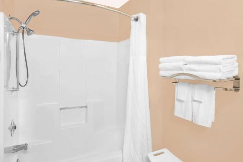 a bathroom with a shower and white towels at Super 8 by Wyndham Sheboygan WI in Sheboygan