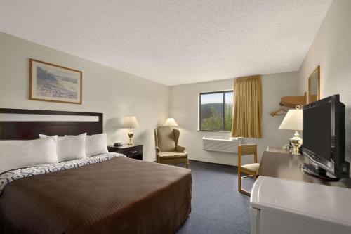 a hotel room with a bed and a television at Super 8 by Wyndham Williams Lake BC in Williams Lake