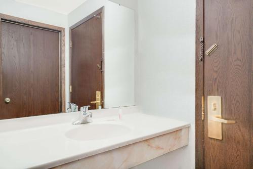 a bathroom with a sink and a mirror at Super 8 by Wyndham Tomah Wisconsin in Tomah