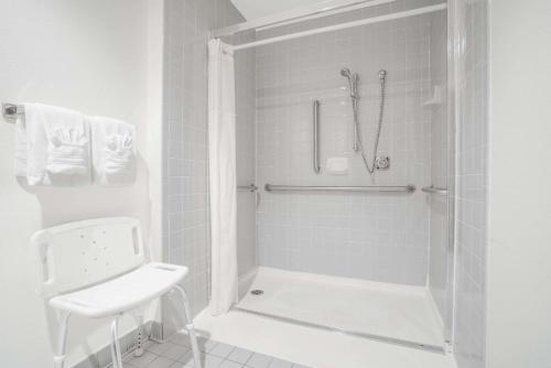 a white bathroom with a shower and a toilet at Super 8 by Wyndham Tomah Wisconsin in Tomah