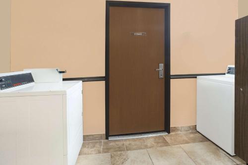 a brown door in a room with a refrigerator at Super 8 by Wyndham Sheboygan WI in Sheboygan