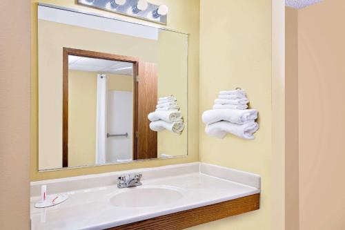 a bathroom with a sink and a mirror and towels at Super 8 by Wyndham Dyersville in Dyersville