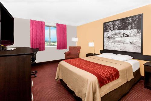 een hotelkamer met een bed en een televisie bij Super 8 by Wyndham Ames in Ames