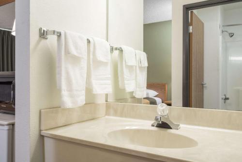 a bathroom with a sink and a mirror and towels at Super 8 by Wyndham Fond Du Lac in Fond du Lac