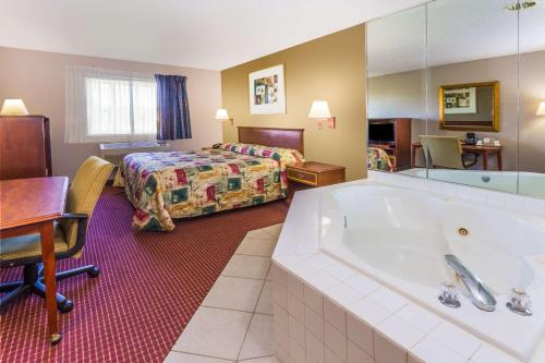 a hotel room with a large tub and a bed at Super 8 by Wyndham Joliet I-55 N/Chicago in Joliet