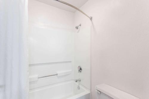a white bathroom with a shower and a toilet at Super 8 by Wyndham Joliet I-55 N/Chicago in Joliet