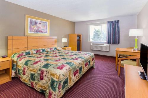 a hotel room with a bed and a television at Super 8 by Wyndham Joliet I-55 N/Chicago in Joliet