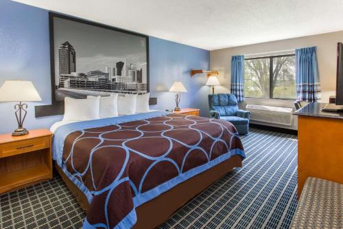 Habitación de hotel con cama y silla en Super 8 by Wyndham Iowa City/Coralville, en Coralville