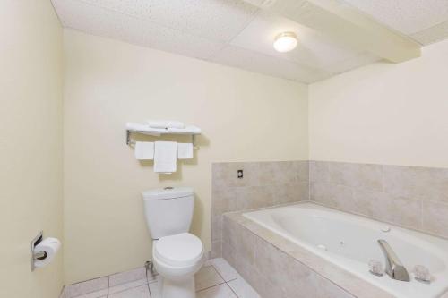 a bathroom with a toilet and a bath tub at Super 8 by Wyndham Newton in Newton