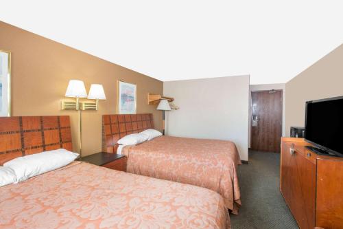 スーシティにあるSuper 8 by Wyndham Sioux City/Morningside Areaのベッド2台と薄型テレビ付きのホテルの部屋