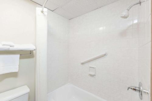 a white bathroom with a shower and a toilet at Super 8 by Wyndham Newton in Newton