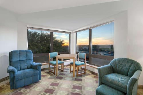 a room with a table and chairs and a large window at Super 8 by Wyndham Toledo in Toledo