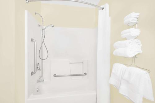 uma casa de banho com um chuveiro e toalhas brancas em Super 8 by Wyndham Ottumwa em Ottumwa