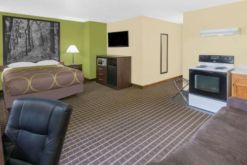 a large hotel room with a bed and a tv at Super 8 by Wyndham Webster City IA in Webster City
