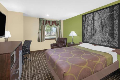 a hotel room with a bed and a flat screen tv at Super 8 by Wyndham Webster City IA in Webster City