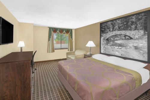 a hotel room with a bed and a flat screen tv at Super 8 by Wyndham Webster City IA in Webster City